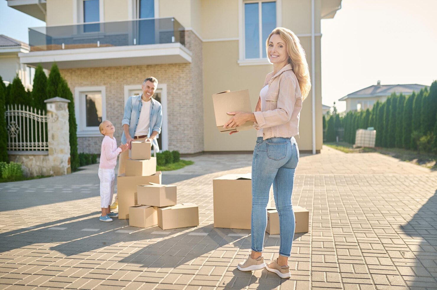 family-moving-new-house-carrying-cardboard-boxes_259150-57049
